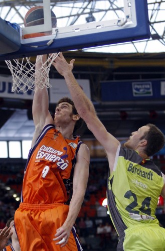 El alero del Valencia Basket Víctor Claver (i) lanza a canasta ante el pívot estadounidense del Blancos de Rueda Valladolid Curtis Borchardt.
