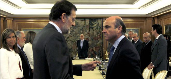 El presidente del Gobierno, Mariano Rajoy (i), conversa con el ministro de Economía y Competitividad, Luis de Guindos (d), al inicio de la reunión del Consejo de Ministros que preside hoy el rey Juan Carlos en el Palacio de la Zarzuela.