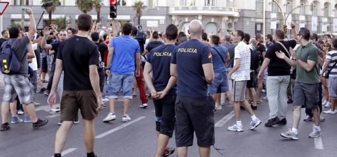 Varios centenares de funcionarios, entre ellos policías, bomberos o profesores, en una manifestación esta tarde en las inmediaciones del Palacio de las Cortes, blindado por la Policía.