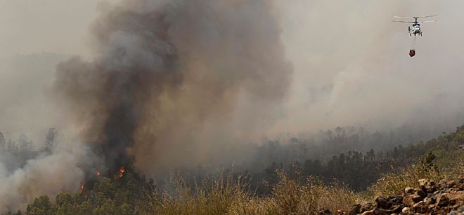 Un helicóptero trabaja para apagar el incendio forestal en la zona de Guayonje.