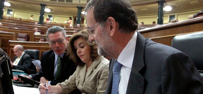 El presidente del Gobierno, Mariano Rajoy, acompañado de la vicepresidenta, Soraya Sáenz de Santamaría, y el ministro de Justicia, Alberto Ruiz-Gallardón (de dcha a izda).