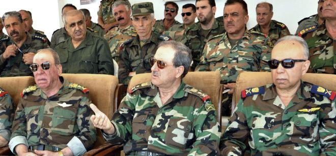 Foto de archivo facilitada por la agencia siria de noticias (SANA) el 10 de julio de 2012 que muestra al ministro sirio de Defensa, Daud Abdelá Rayiha (c), durante una ceremonia en un lugar no identificado.