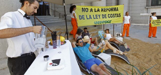 Activistas de Greenpeace han instalado esta mañana una playa a la entrada del Ministerio de Medio Ambiente, en Madrid.