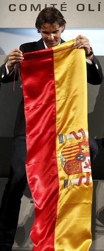 El tenista español Rafael Nadal dobla la bandera de España que portará como abanderado del equipo español en la ceremonia de inauguración de los Juegos Olímpicos de Londres 2012 y que recibió hoy, 14 de julio de 2012, en la sede del Comité Olímpico Español (COE).