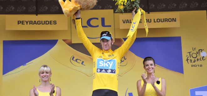 El ciclista británico del equipo Sky Procycling, saluda desde el podio como líder de la general.
