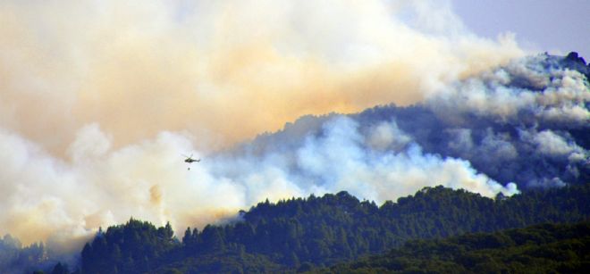 Un helicóptero en la montaña de Nambroque trabajan en las labores de extinción del incendio.