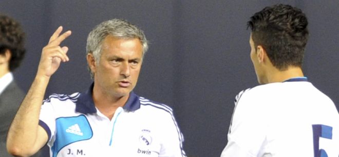 El director técnico del Real Madrid Jose Mourinho (i) da instrucciones al jugador Nuri Sahin (d) .