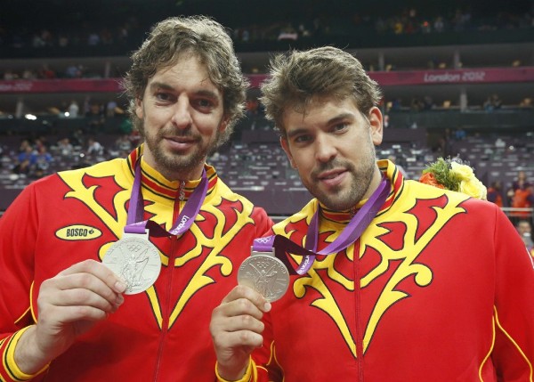 Los españoles Pau Gasol (i) y Marc Gasol en el podio tras ganar el equipo la medalla de plata en la final olímpica de baloncesto.