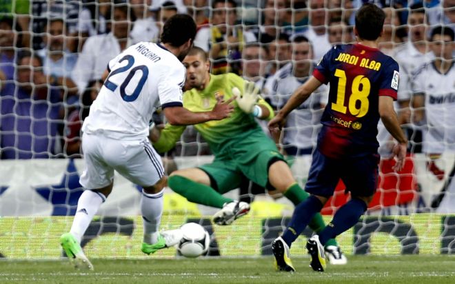 El delantero argentino del Real Madrid Gonzalo Higuaín (i) chuta a puerta para conseguir el primer gol blanco frente al FC Barcelona.