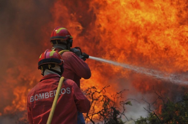 Unos bomberos trabajan en las labores de extinción de un incendio.