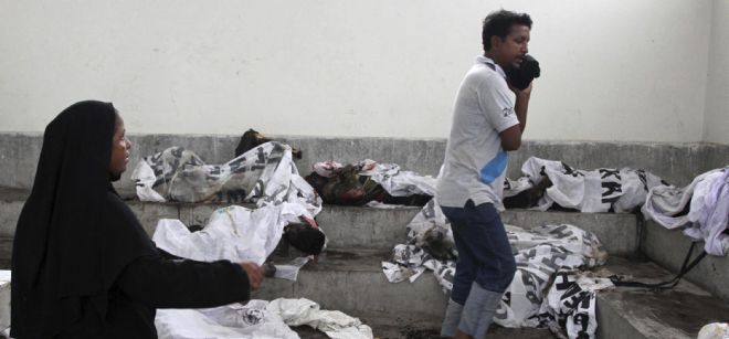 Los cuerpos de las víctimas del incendio en una fábrica textil yacen en un deposito de cadáveres en Karachi.