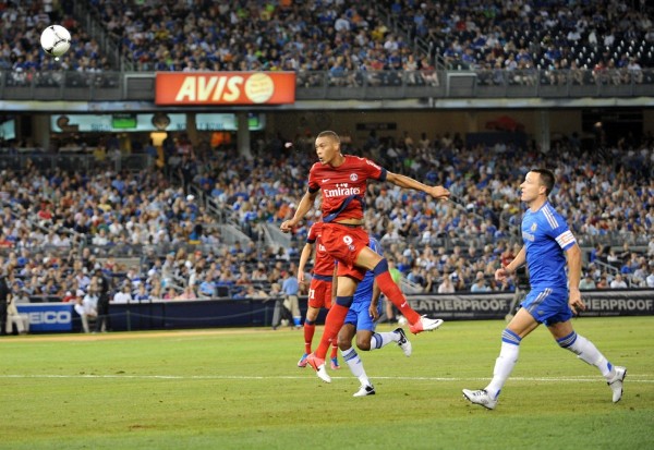 El jugador del Paris Saint-Germain Guillaume Hoarau cabecea el balón ante John Terry, del Chelsea FC.