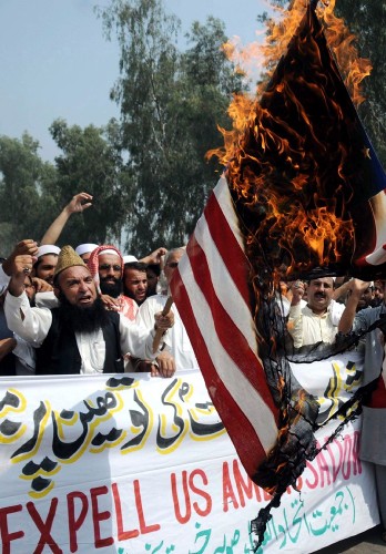 Paquistaníes prenden fuego a una bandera estadounidense.