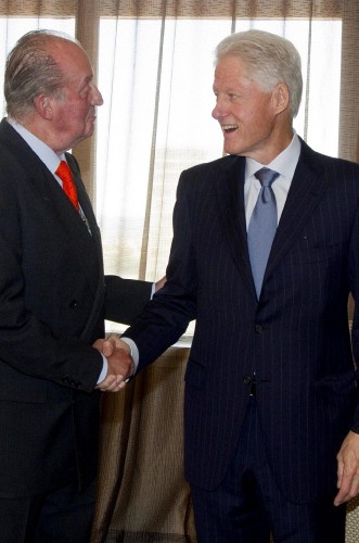 El rey Juan Carlos I de España (i) saluda al expresidente de Estados Unidos Bill Clinton.