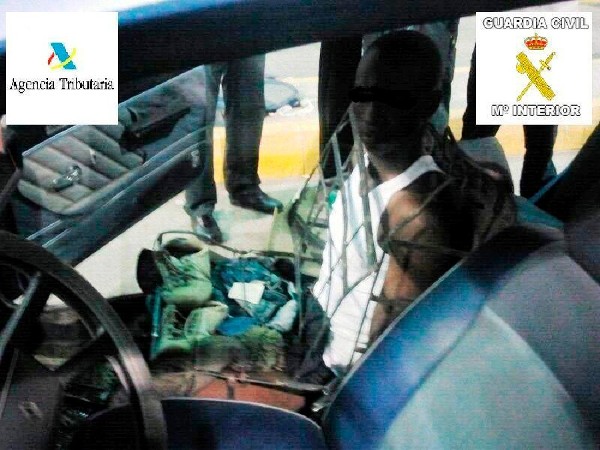 Fotografía facilitada por la Guardia Civil de la detención de un inmigrante que accedía a Melilla desde Marruecos camuflado como un asiento de un vehículo, sobre el que se sentaba una persona para eludir los controles de acceso a la ciudad autónoma.