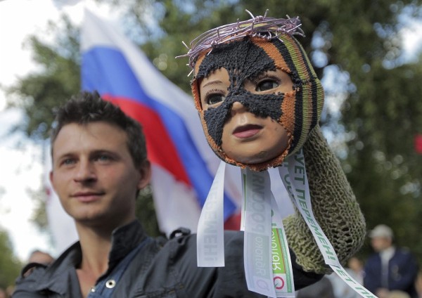 Un activista de la oposición muestra una muñeca enmascarada que representa a un miembro del grupo Pussy Riot.