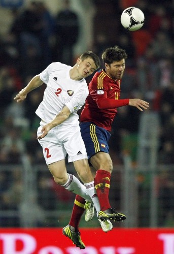 El jugador de España Xabi Alonso (d) disputa el balón con Stanislav Dragun.