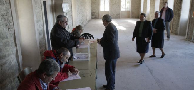 Varios ancianos ejercen su derecho al voto en un colegio electoral en San Pedro de Meixide, en Palas de Rei, para las elecciones gallegas.
