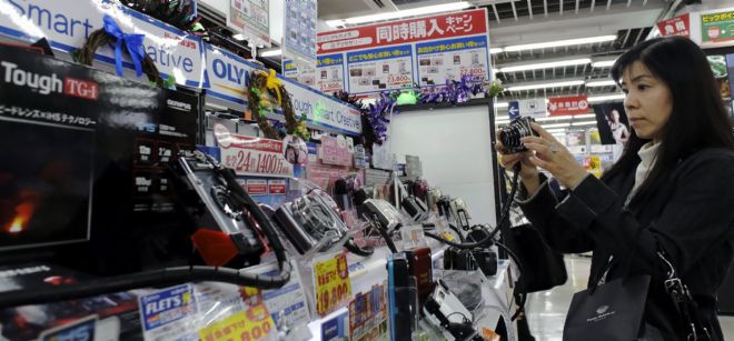 Una cliente prueba una cámara dispuesta en un mostrador de cámaras Olympus en una tienda de Tokio.