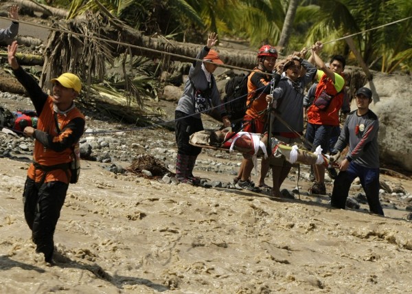 Miembros de los equipos de rescate trasladan un superviviente del tifón 