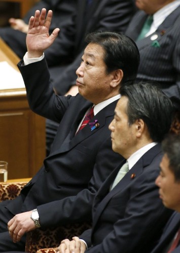 El primer ministro nipón, Yoshihiko Noda, alza la mano para responder a una pregunta formulada por el presidente del opositor Partido Liberal Demócrata (PLD), Shinzo Abe.