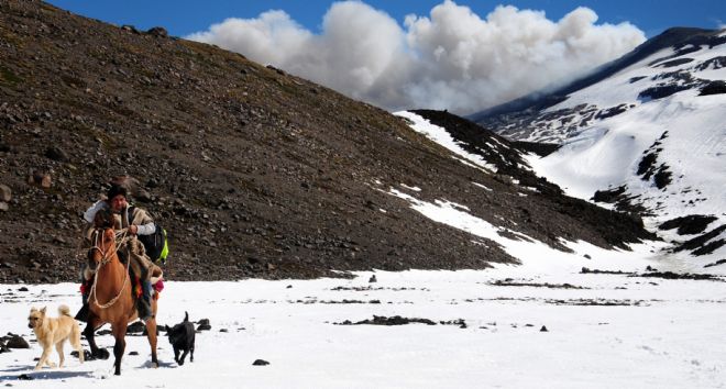 Un arriero chileno cabalga frente a las fumarolas del volcán Copahue.