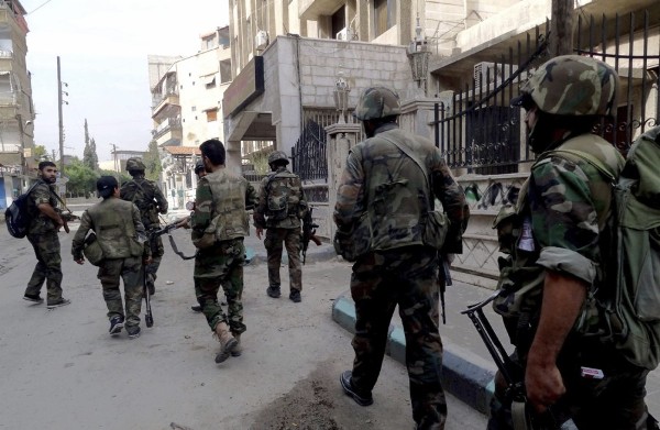 Soldados sirios patrullando una calle de Harasta, al este de Damasco.