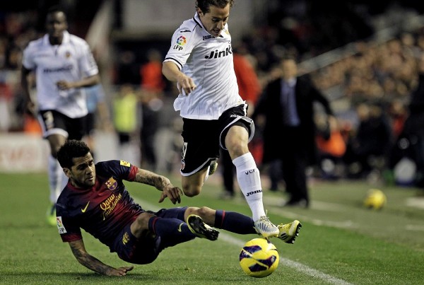El centrocampista mexicano del Valencia CF Andrés Guardado (d) controla el balón ante el defensa brasileño del FC Barcelona Dani Alves (i), en un momento del partido de la vigésima segunda jornada de liga en Primera División que se disputa esta noche en el estadio de Mestalla.