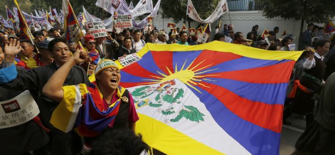Monjes tibetanos residentes en la India sujetan una bandera del Tíbet durante una protesta en Nueva Delhi.