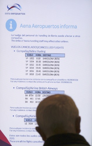 Una persona observa una información sobre vuelos cancelados en el aeropuerto de Barajas.