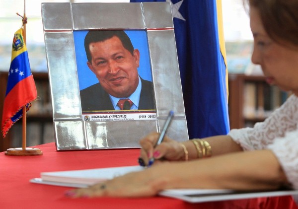 Una mujer firma un libro para expresar sus condolencias por el fallecimiento del presidente venezolano Hugo Chávez.