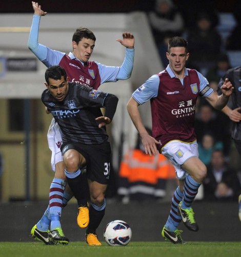 El jugador del Manchester City, el argentino Carlos Tevez (c), adelanta al jugador Mathew Lowton del Aston Villa.