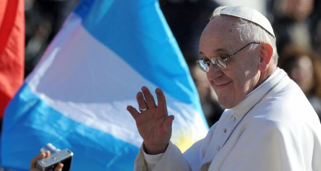 El papa Francisco pasa ante una bandera argentina.