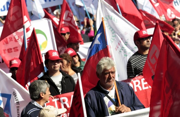 Manifestantes participan hoy, miércoles 1 de mayo de 2013, en la marcha convocada por la Central Unitaria de Trabajadores para celebrar el Día Internacional del Trabajo, en Santiago (Chile). Miles de chilenos salieron a las calles para conmemorar el Día Internacional del Trabajo y exigir una reforma tributaria, un nuevo sistema de pensiones y una nueva regulación laboral, en una marcha empañada por graves disturbios.