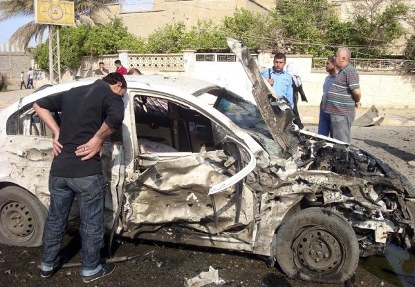 Varios iraquíes inspeccionan el escenario de un ataque con coche bomba en Kirkuk, al norte de Irak, el 15 de abril de 2013. Al menos trece personas murieron y 157 resultaron heridas en una cadena de ataques en distintos puntos de Irak, informaron a Efe fuentes policiales.