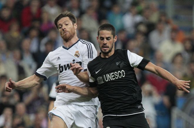 El centrocampista del Real Madrid Xabi Alonso (i) disputa el balón a Isco.