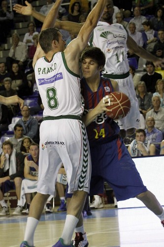El ala-pivot montenegrino del Regal Barcelona, Marko Todorovic (d), aguanta la pelota ante el alero estadounidense Andy Panko (i), del Unicaja, durante el partido de liga ACB disputado hoy en el Palau Blaugrana.