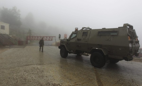 Un soldado israelí inspecciona un vehículo militar en la entrada de la base militar israelí del Monte Hermón.