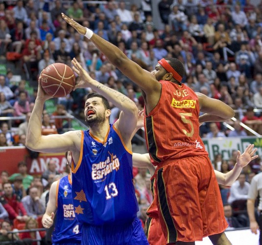 El pívot del Valencia Basket Vitor Faberani (i) entra a canasta frente al pívot norteamericano del CAI Zaragoza, Joseph Jones, durante el segundo partido.