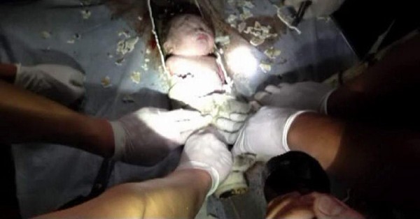 China: Imagen de vídeo facilitada el 28 de mayo de 2013, de un recién nacido, de apenas dos días, siendo atendido por unos bomberos y unos médicos en el condado de Pujiang, en la provincia de Zhejiang, China, en el momento en el que consiguen liberarlo dos horas después de ser localizado en una tubería de tan sólo 10 centímetros de diámetro, el pasado 25 de mayo. La policía localizó a la madre del niño en la noche de ayer, 27 de mayo. La mujer afirmó que ella estaba usando el wáter cuando el niño cayó accidentalmente a él. La policía aún está investigando el caso. El bebé se encuentra estable.