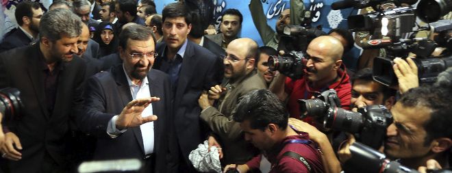 El excandidato presidencial conservador derrotado Mohsen Rezaei (c) saluda a la prensa a su llegada al registro de su candidatura para las elecciones presidenciales.