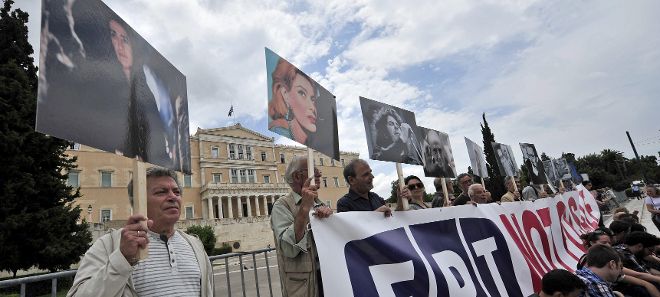 Manifestantes sostienen fotografías de conocidos artistas y escritores durante una manifestación en contra del cierre de la televisió pública griega ante el Parlamento griego en Atenas (Grecia).