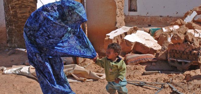 Un niño saharaui se agarra a su madre.