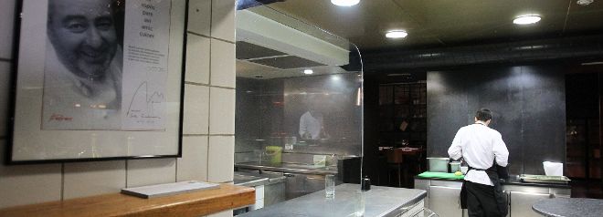 Vista de la cocina del restaurante Can Fabes de Sant Celoni, presidida por una gran fotografía del malogrado cocinero catalán.