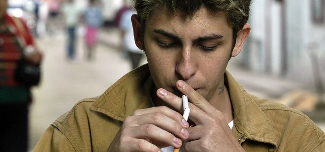 Un jóven cubano enciende un cigarrillo en La Habana.
