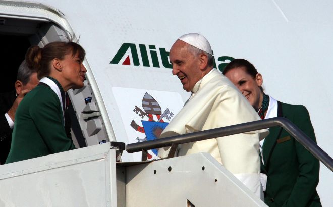 El papa Francisco saluda a las azafatas de la compañía italiana Aitalia al subir a bordo del avión, en el aeropuerto Fiumincino de Roma (Italia).