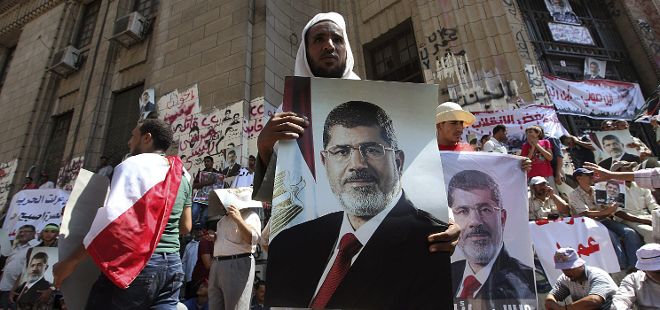 Defensores del derrocado mandatario Mohamed Mursi muestran pancartas durante una manifestación en el Ministerio de Defensa en El Cairo, Egipto hoy.