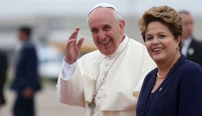 El papa Francisco (i) saluda mientras camina junto a la presidenta de Brasil Dilma Rousseff a su llegada a Río de Janeiro.