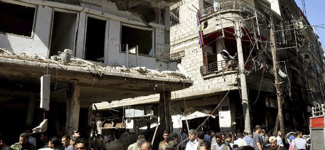 Varios vecinos que inspeccionan las daños producidos tras una explosión que ha tenido lugar en el barrio de Jaramana, en Damasco, Siria, el 25 de julio de 2013.