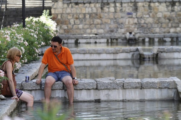 Una pareja se refresca en unas de las fuentes de Córdoba.